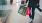 a person holding a camera and shopping bags