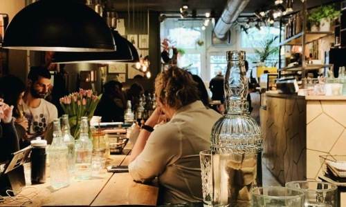 people sitting at tables in a restaurant